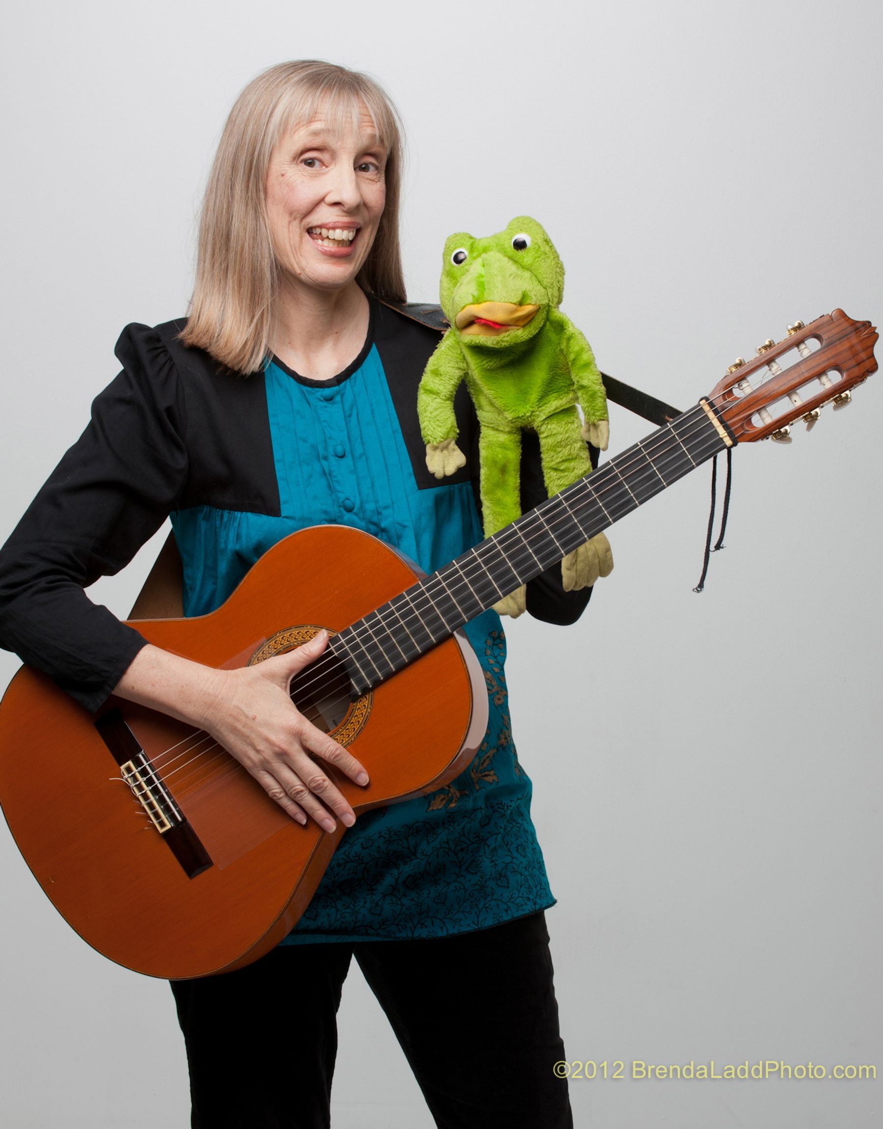 sue with a guitar and green frog puppet
