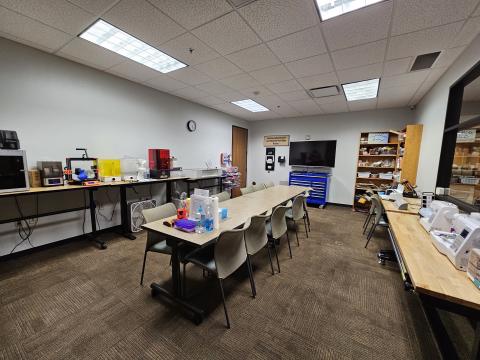 The makerspace in the Tye Preston Memorial Libraray containing 3D printers, Glowforge laser machine, Cricut, sewing machine, embroidery machine, TV and material swap shelves.