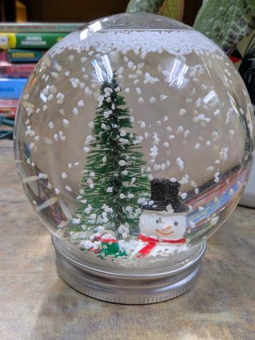 photo of snowglobe with snowman and tree inside